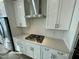 Modern kitchen features a stainless steel range hood, white cabinetry, and a gas cooktop at 1200 Alston Landing Way # 05, Cary, NC 27519