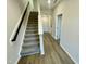 Carpeted staircase with modern black railing leading to an upper level at 1200 Alston Landing Way # 05, Cary, NC 27519