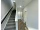 Hallway with stairs, a mix of carpet and hardwood flooring, and doors leading to various rooms in the house at 1202 Alston Landing Way # 06, Cary, NC 27519