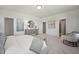 Serene main bedroom with a gray dresser, a round gold mirror, and an adjacent sitting area at 1234 Coach Station Alley # 201, Raleigh, NC 27601