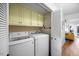 Well-lit laundry room featuring a modern washer and dryer set and ample cabinet space above at 1303 Dylan Heath Ct, Raleigh, NC 27608