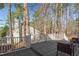 An inviting wooden back deck with white railing offers a private outdoor living space amidst a wooded backyard setting at 138 Sherwood Ln, Sanford, NC 27332
