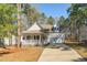 Charming home featuring a welcoming front porch, green shrubbery, and an attached two car garage at 138 Sherwood Ln, Sanford, NC 27332