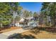 Exterior view of a charming home with an attached garage and a long driveway surrounded by mature trees at 138 Sherwood Ln, Sanford, NC 27332