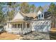 Charming home featuring a welcoming front porch, green shrubbery, and an attached two car garage at 138 Sherwood Ln, Sanford, NC 27332