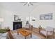 Bright living room featuring vaulted ceilings, a ceiling fan, a fireplace and sleek wood floors at 138 Sherwood Ln, Sanford, NC 27332