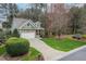 Charming home featuring a stone and siding exterior, manicured lawn, and a two-car garage on a tree-lined lot at 1428 Heritage Links Dr, Wake Forest, NC 27587