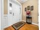 Inviting foyer features a white door with glass inserts, wood floors, and a decorative flower arrangement on a table at 1428 Heritage Links Dr, Wake Forest, NC 27587