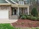 Charming stone-clad home with a welcoming front porch and manicured landscaping at 1428 Heritage Links Dr, Wake Forest, NC 27587