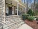 Inviting front porch with stone steps, elegant columns, and manicured landscaping at 1428 Heritage Links Dr, Wake Forest, NC 27587
