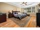 Spacious main bedroom featuring a large bed, hardwood floors, and a tray ceiling at 1428 Heritage Links Dr, Wake Forest, NC 27587