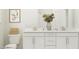 Bright bathroom showcasing a double vanity with sleek hardware, decorative vase with flowers, and a framed picture at 1524 Goldfinch Perch Ln, Knightdale, NC 27545