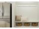 Mudroom area with built-in bench seating, hooks, and storage baskets, adjacent to fridge at 1524 Goldfinch Perch Ln, Knightdale, NC 27545