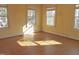 Empty bedroom with hardwood floors and three windows at 1703 St. Mary'S St, Raleigh, NC 27608