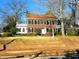 Traditional brick home featuring a red tile roof, green shutters, and a manicured front lawn at 1703 St. Mary'S St, Raleigh, NC 27608