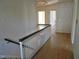 Upstairs hallway with hardwood floors, white and dark stained banister, and wallpaper at 1703 St. Mary'S St, Raleigh, NC 27608