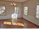 Spacious living room featuring hardwood floors, large windows, and modern chandelier at 1703 St. Mary'S St, Raleigh, NC 27608