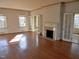 Living room with hardwood floors, a fireplace, and multiple windows providing ample natural light at 1703 St. Mary'S St, Raleigh, NC 27608