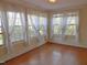 Bright room with hardwood floors, many windows with white sheer curtains, and a chandelier light fixture at 1703 St. Mary'S St, Raleigh, NC 27608