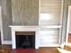 Living room fireplace with red tile, white mantle, and white built-in shelving at 1703 St. Mary'S St, Raleigh, NC 27608