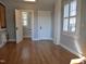 Open room with hardwood floors, an open bathroom door, and windows with blinds for privacy at 1703 St. Mary'S St, Raleigh, NC 27608
