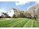 Beautiful home with manicured lawn and landscaping, plus exterior staircase leading to an upper balcony at 1914 Tweed Ln, Burlington, NC 27215