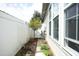 Side yard with well-maintained lawn, decorative plants, and a privacy fence at 1914 Tweed Ln, Burlington, NC 27215