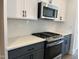 Modern kitchen featuring stainless steel appliances, white backsplash, and sleek gray cabinets at 1919 Plott Balsam Dr, Wendell, NC 27591