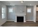 Bright living room showcasing a fireplace with white mantel and modern wood-look flooring at 1919 Plott Balsam Dr, Wendell, NC 27591