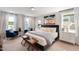 Serene main bedroom with plush bedding, large windows, and comfortable seating area at 1919 Plott Balsam Dr, Wendell, NC 27591