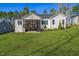 Back exterior with a well-maintained lawn, screened porch, and lush landscaping at 271 Sacred Fire Rd, Louisburg, NC 27549