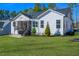Back exterior with a well-maintained lawn, screened porch, and lush landscaping at 271 Sacred Fire Rd, Louisburg, NC 27549