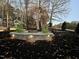 Inviting outdoor fire pit area with stone surround, lighting, and Adirondack chairs in a wooded setting at 271 Sacred Fire Rd, Louisburg, NC 27549