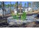 Backyard stone fire pit with green rocking chairs and view of house at 271 Sacred Fire Rd, Louisburg, NC 27549