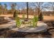 A backyard fire pit seating area with green rocking chairs and landscape at 271 Sacred Fire Rd, Louisburg, NC 27549