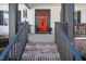 Inviting front porch with brick steps, a red door, and decorative accents at 271 Sacred Fire Rd, Louisburg, NC 27549