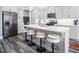Modern kitchen featuring an island with seating, gray cabinetry, and stainless steel appliances at 271 Sacred Fire Rd, Louisburg, NC 27549