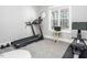 Bright workout room with treadmill, rowing machine, wall mirror, and a view from the window at 271 Sacred Fire Rd, Louisburg, NC 27549
