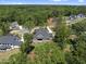 An aerial view showing a gray home with black roof, surrounded by mature trees and manicured lawns in a wooded area at 2829 Theresa Eileen Way, Raleigh, NC 27603