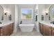 Bright bathroom with double vanities and a soaking tub under a large window at 2829 Theresa Eileen Way, Raleigh, NC 27603