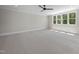 Spacious bedroom with neutral carpet, ceiling fan, and large windows providing natural light at 2829 Theresa Eileen Way, Raleigh, NC 27603