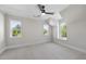 Bright bedroom featuring plush carpeting, multiple windows, and a ceiling fan for added comfort at 2829 Theresa Eileen Way, Raleigh, NC 27603