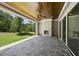 Relaxing covered patio featuring a stone fireplace, stained wood ceiling, and stone flooring overlooking the spacious lawn at 2829 Theresa Eileen Way, Raleigh, NC 27603