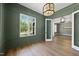 Green dining room with hardwood floors, window views and modern light fixtures at 2829 Theresa Eileen Way, Raleigh, NC 27603
