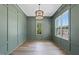 This dining room features green walls with paneling, hardwood floors, and a modern light fixture at 2829 Theresa Eileen Way, Raleigh, NC 27603