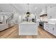 Open-concept kitchen with island, stainless appliances, and hardwood flooring overlooking the living room at 2829 Theresa Eileen Way, Raleigh, NC 27603