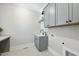 Contemporary laundry room with gray cabinets, sink, countertops and modern fixtures at 2829 Theresa Eileen Way, Raleigh, NC 27603