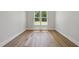 Empty office with hardwood floors, natural light, and a view of lush green trees at 2829 Theresa Eileen Way, Raleigh, NC 27603
