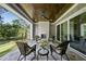 Covered stone patio featuring a fireplace, comfortable seating and landscape views at 2829 Theresa Eileen Way, Raleigh, NC 27603