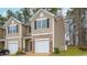 A two story tan townhome is enhanced with stone accents and features a one car garage at 2832 Egert Dr, Haw River, NC 27258